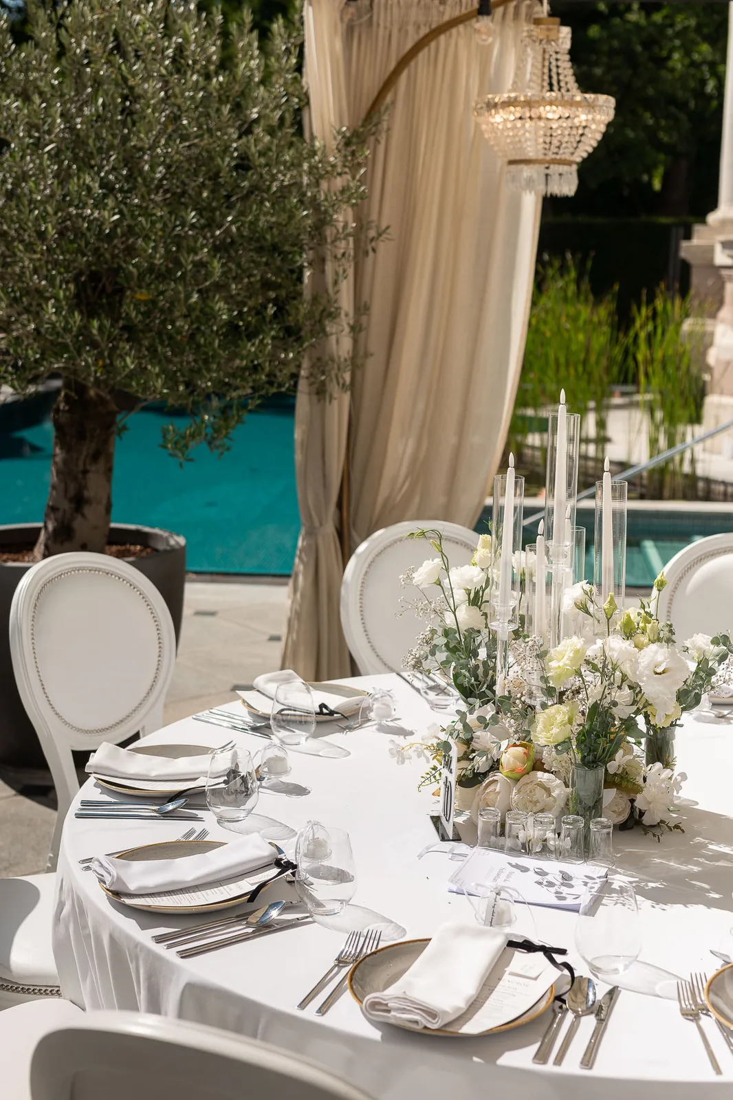 Luxury poolside wedding table with chandelier and white roses
