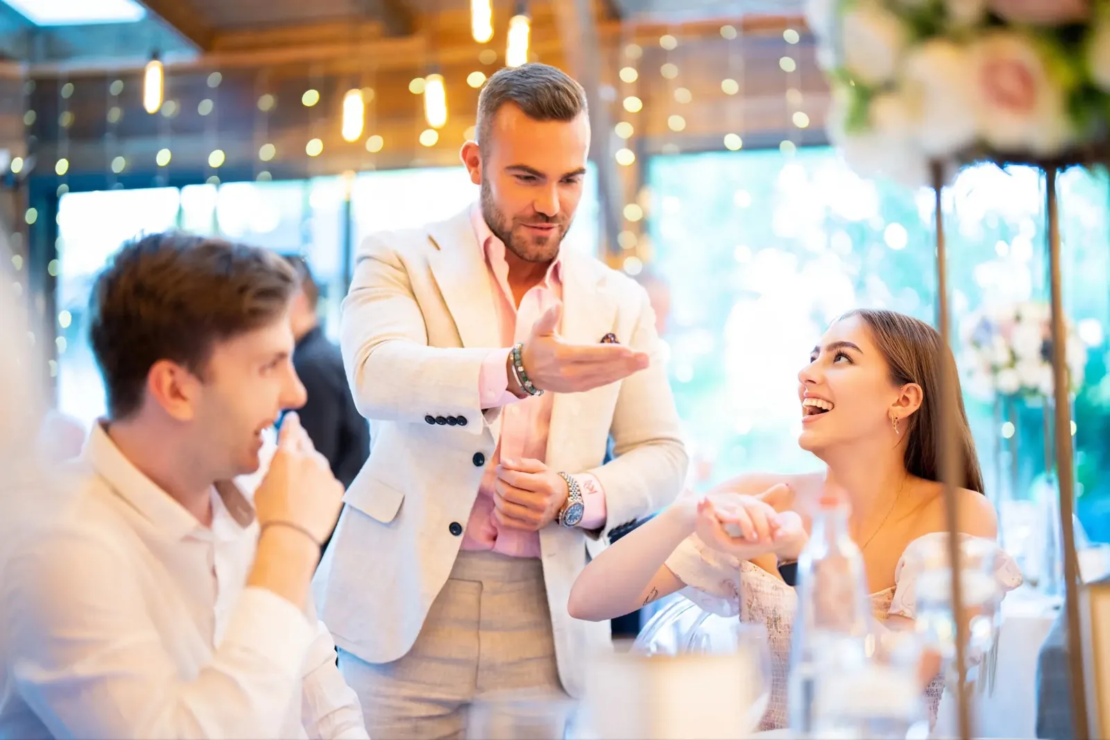 Wedding guests reacting with astonishment as Matteo Cammisa performs close-up magic during a cocktail hour