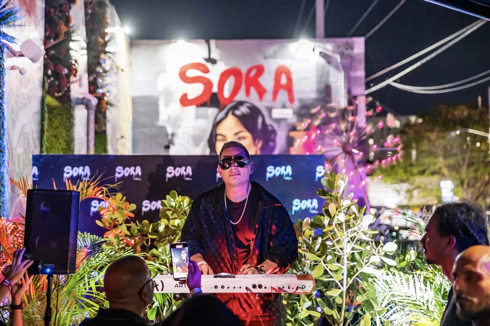 Scott Storch performing on keys under the Sora sign at the Wynwood grand opening